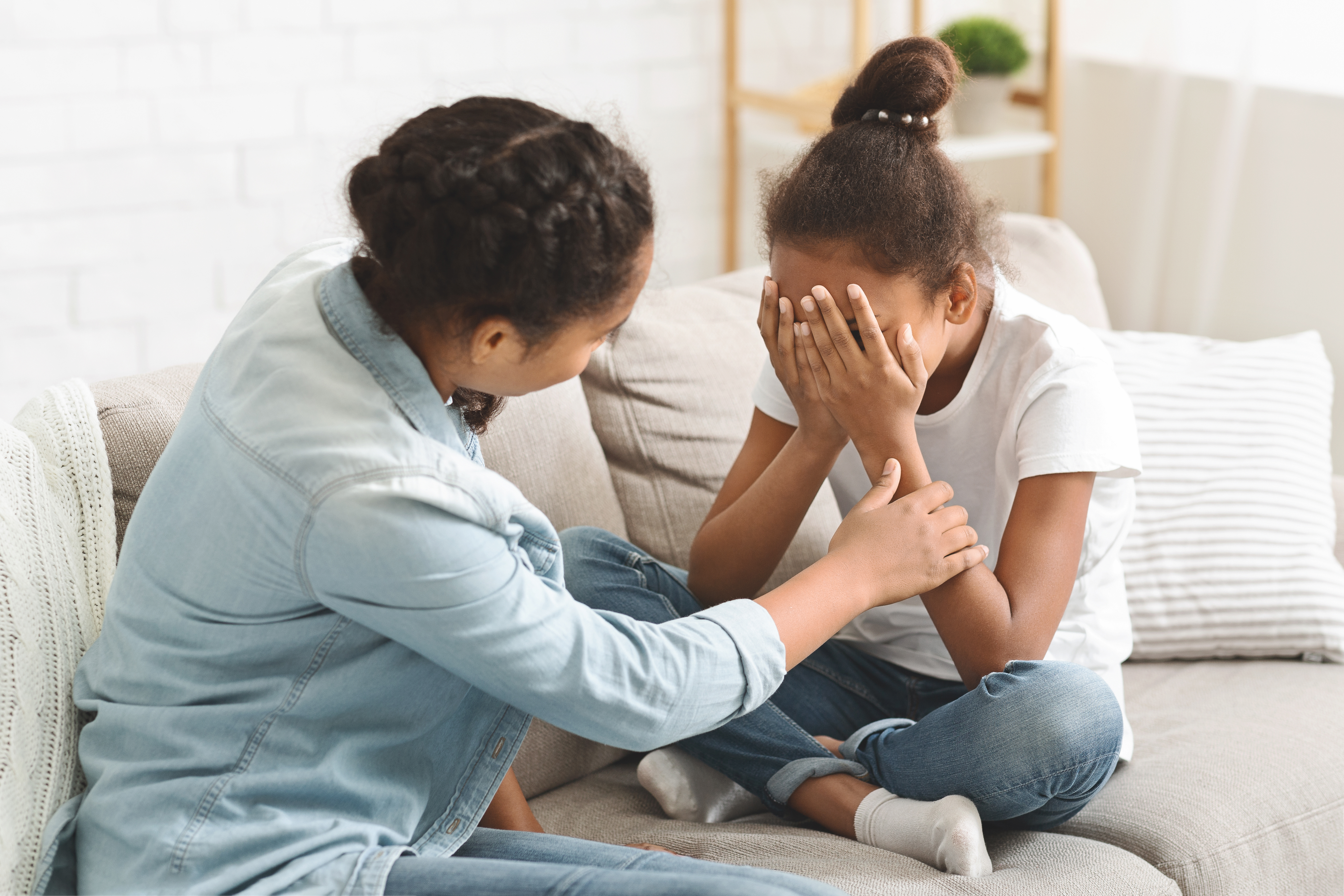 Adult offering comfort and support to an upset child during a conversation about challenges related to EBSA.