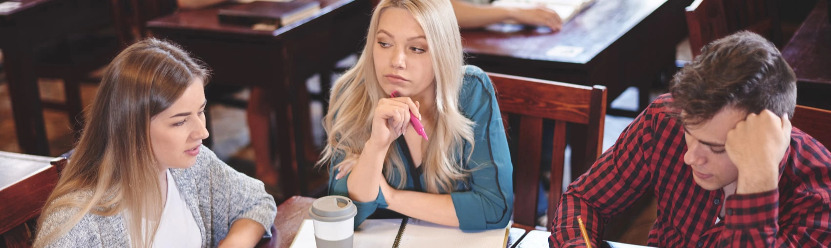 Three older teenager students revising together. 