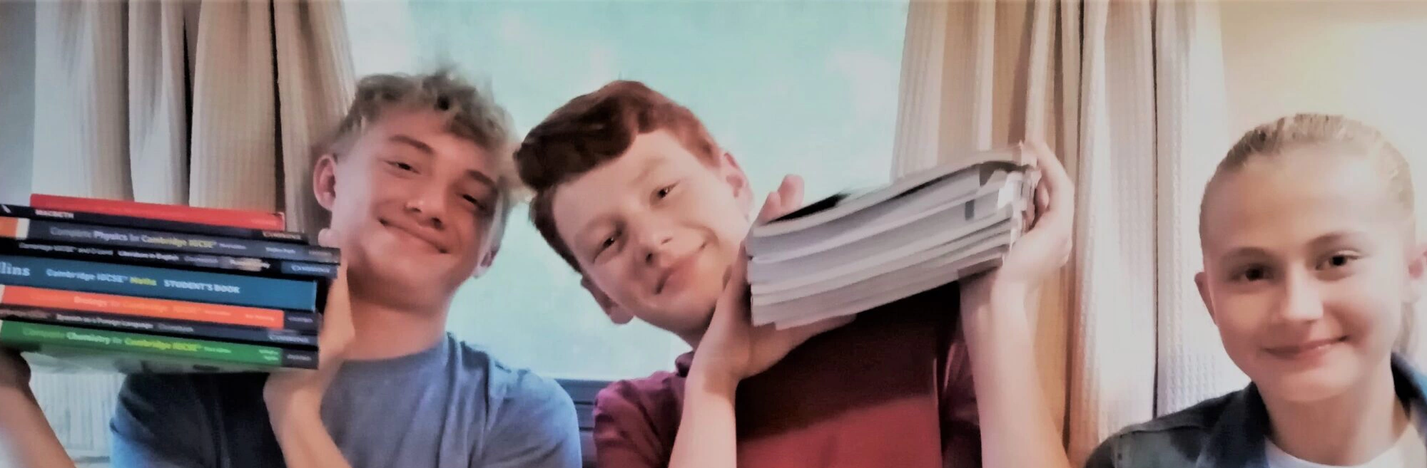 Wolsey Hall Oxford students, Sebastian, Aiden, and Ella with their textbooks. 