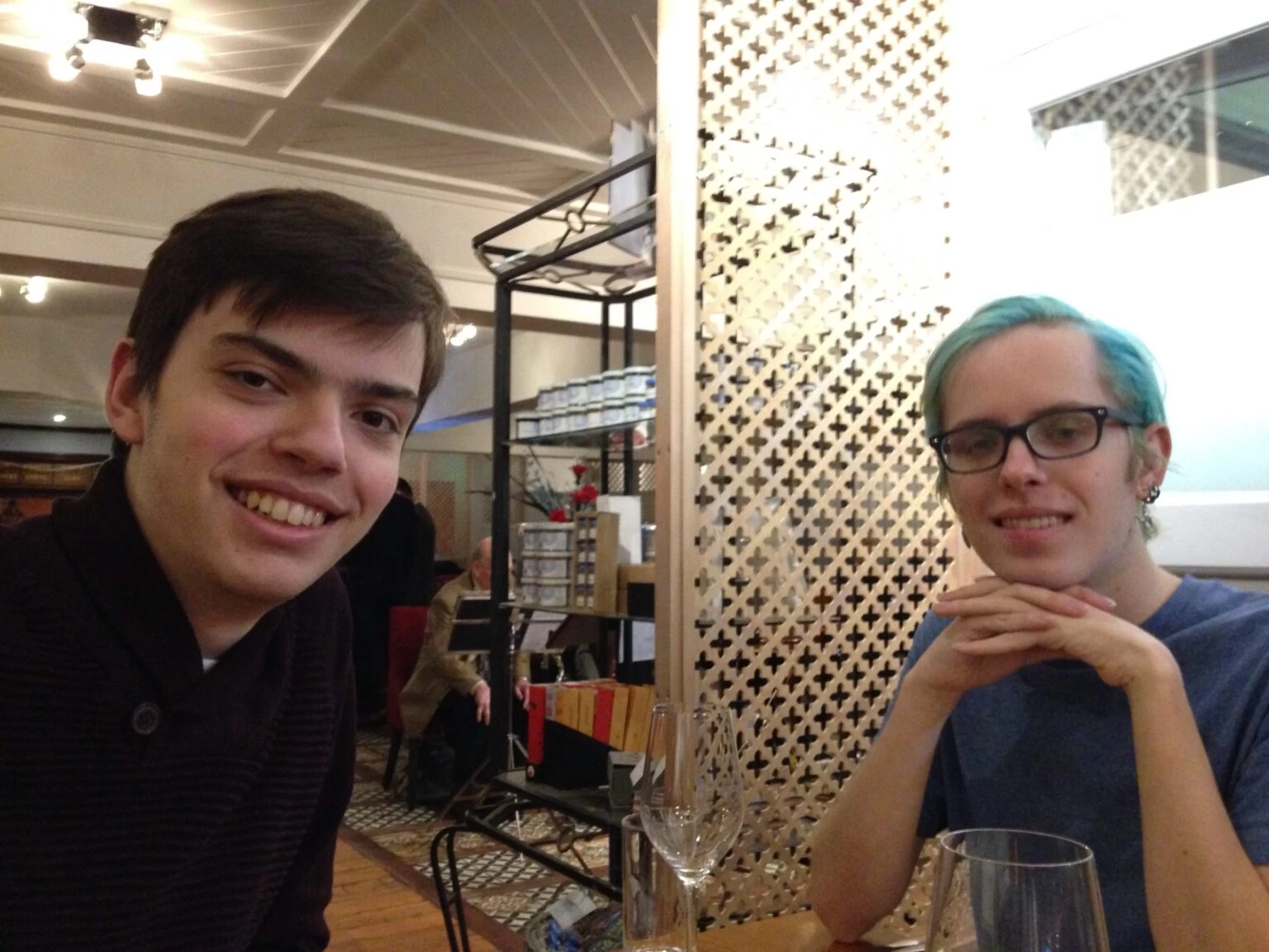Two Wolsey Hall Oxford students at a table with glasses, one smiling at the camera and the other looking forward.