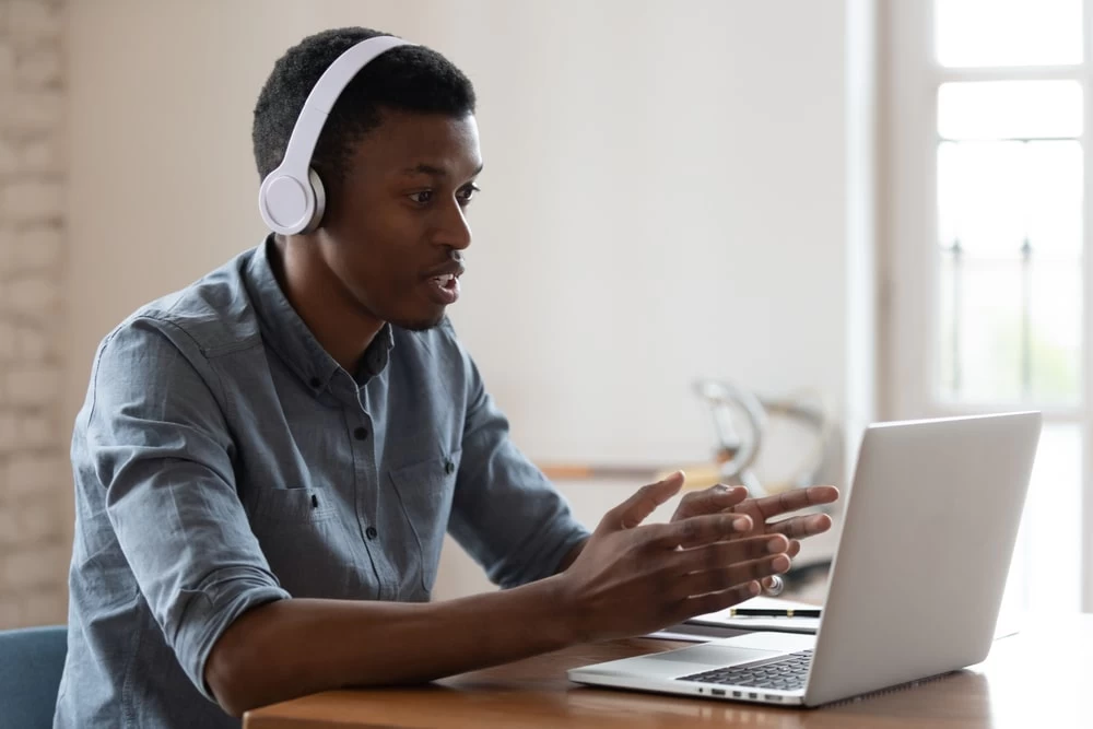 A male student using a laptop to study a language. 