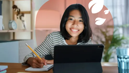 A homeschooling female student with short black hair studying at her bedroom desk, smiling at the camera.
