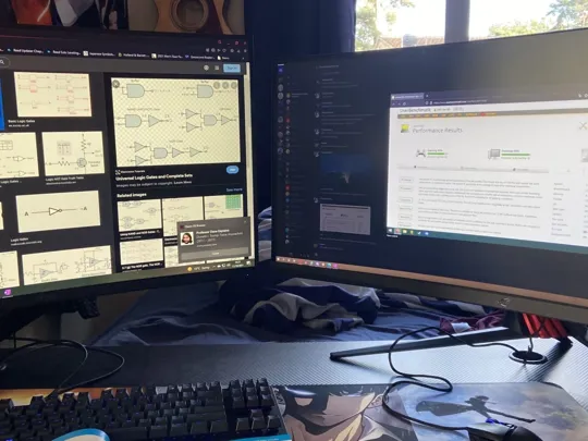 A desk with two large computer monitors displaying educational content, a keyboard, and a mousepad, indicating an organised study space.