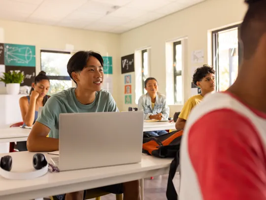 Students working on laptops in a bright, modern classroom of a pamoja school