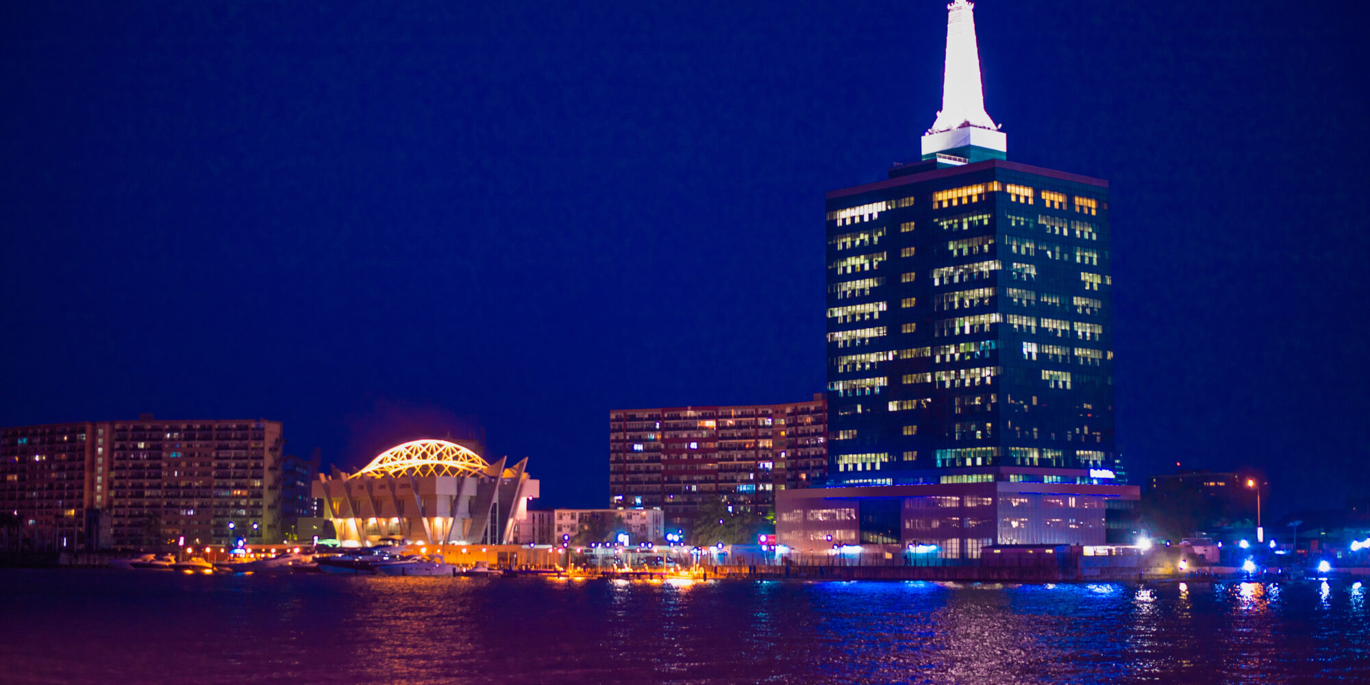 A landscape view of a Nigerian city's skyline at night, lit up by building and street lights. 