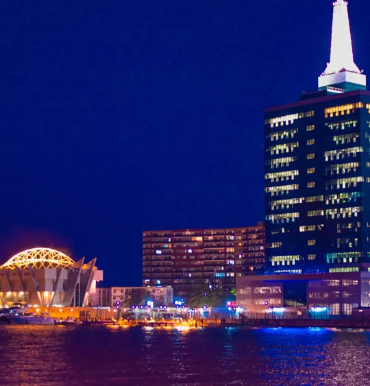 A landscape view of a Nigerian city's skyline at night, lit up by building and street lights.