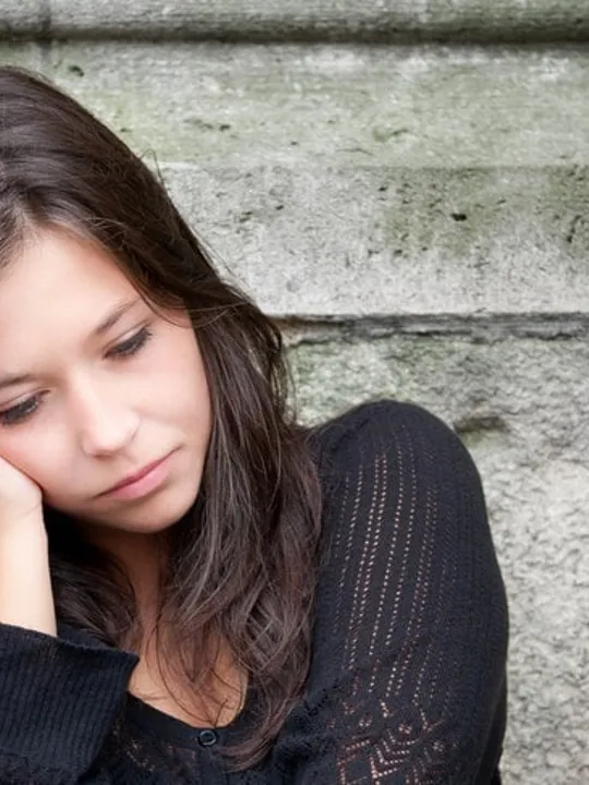 Young girl looking deflated at thought of going to school, demonstrating characteristics of school phobia.