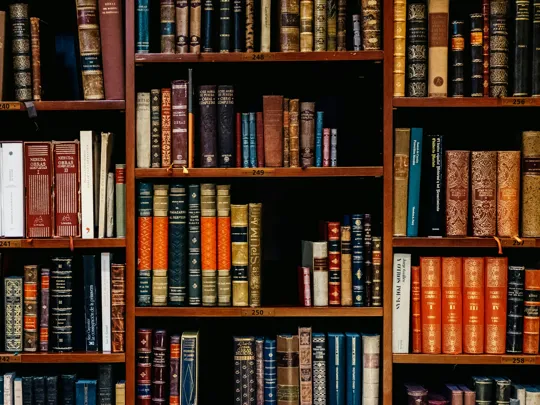 A photograph of lots of old books on a bookshelf.