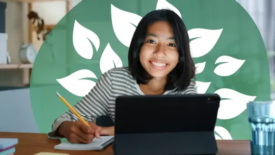 A homeschooling female student with short black hair studying at her bedroom desk, smiling at the camera.