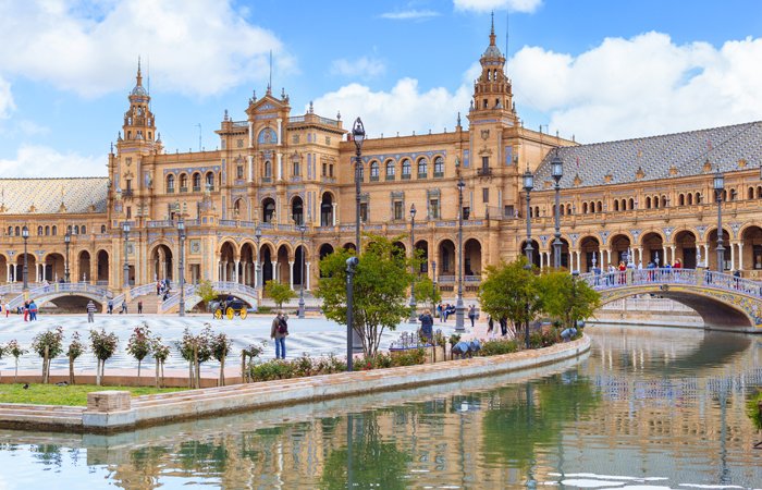 A landscape view of a Spanish city, with a river in the forefront. 