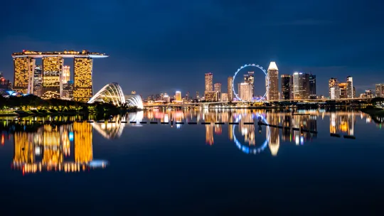 Singapore skyline at night with Marina Bay Sands and city lights reflected in the water