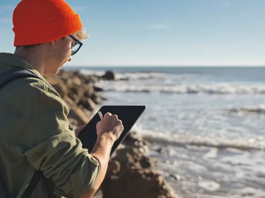 Marine scientist observing the sea and making note of their findings.