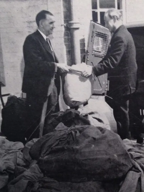 An old photograph of a Wolsey Hall Oxford employee handing correspondence course papers to a postman. The photo is taken from our 1964 prospectus, with the caption: From our 1964 prospectus: “The Post leaves Wolsey Hall. Letters and Lessons leave the College on their journey to all five continents.”