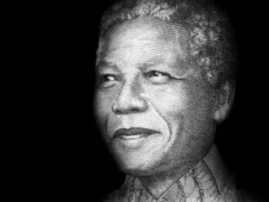 A black and white image of Wolsey Hall Oxford alumnus Nelson Mandela, former President of South Africa. Nelson is smiling off camera to the left.