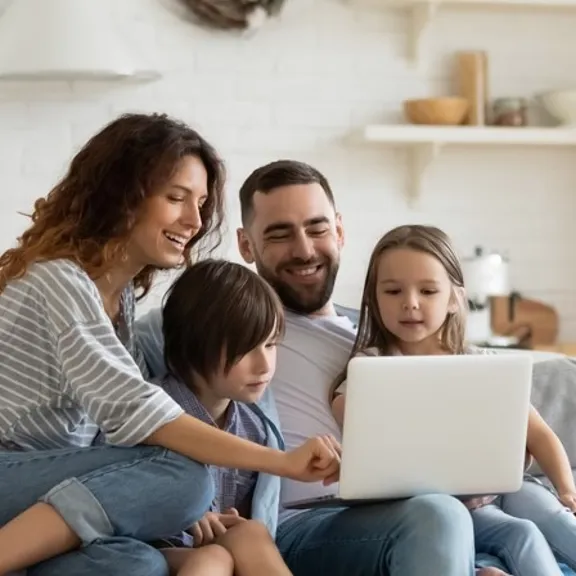 An entire family sat around a laptop.