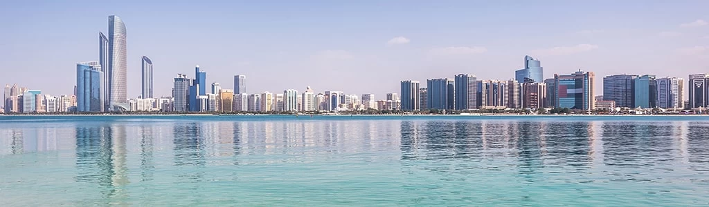 Skyline of Abu Dhabi reflected in clear turquoise water, representing global learning opportunities