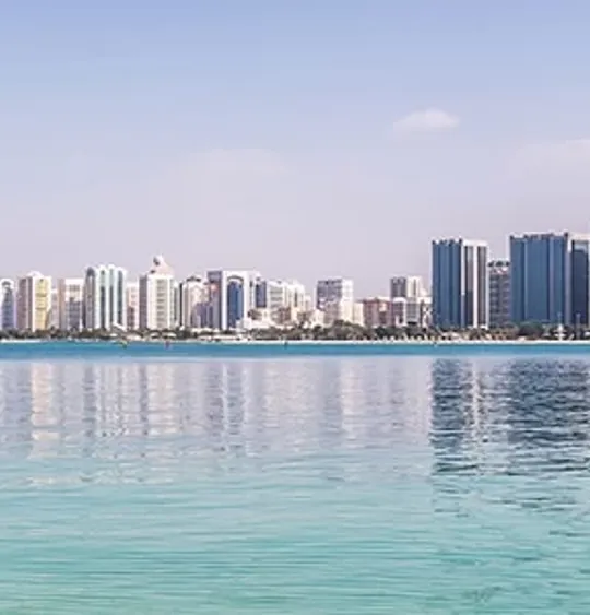 Skyline of Abu Dhabi reflected in clear turquoise water, representing global learning opportunities