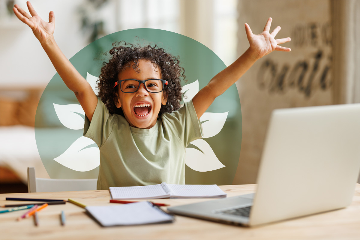  A happy child in glasses sits at a desk with a laptop and open notebooks, raising their arms in excitement. A green translucent overlay with white leaves is behind them.