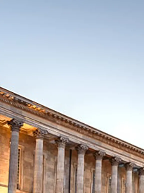 Neoclassical architecture of Birmingham Town Hall and Queen Victoria statue at dusk.