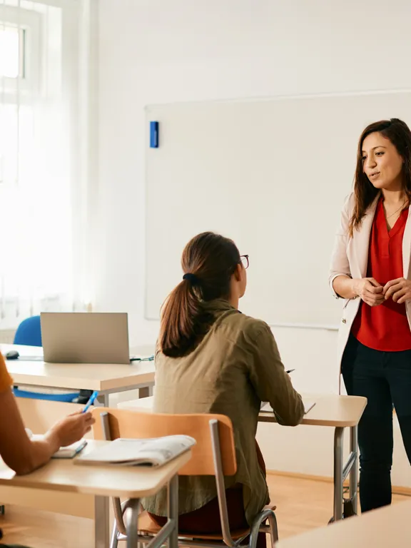A teacher standing up in front of a class of students