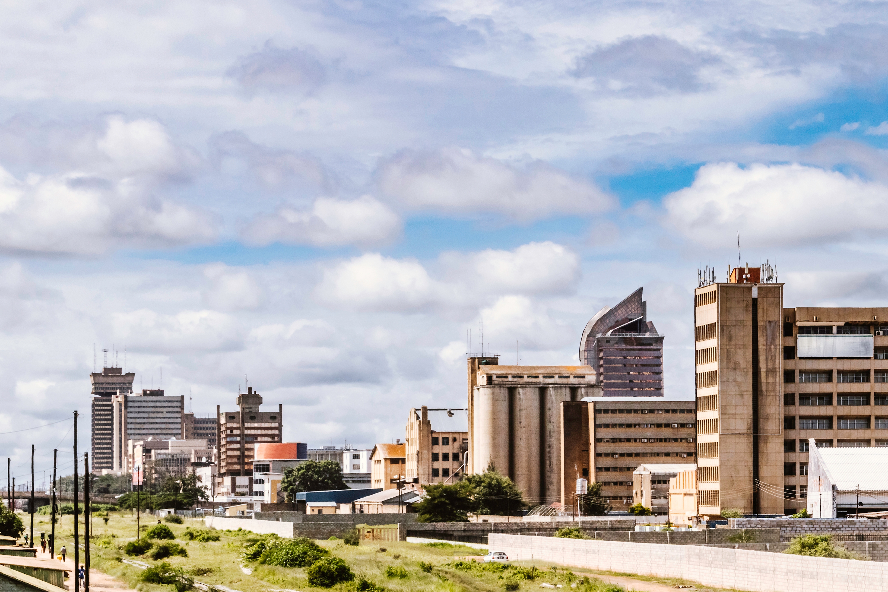 City skyline of Lusaka, Zambia under a cloudy sky with modern and traditional architecture.