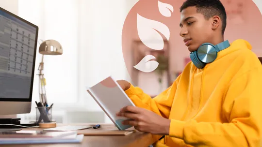 A focused teenage student works at his desk with a schedule on his computer screen, illustrating one of the key benefits of structured homeschooling: a personalised and organised learning environment.