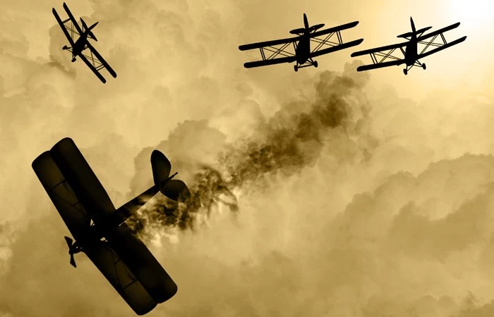 Old war planes in a dog fight, with one that has been shot down. 