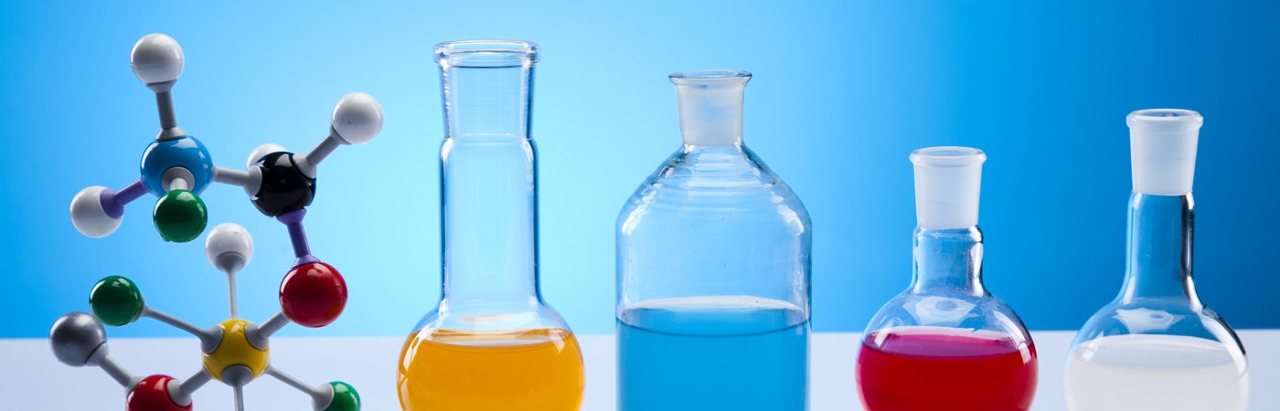 Molecular model and various glass beakers filled with coloured liquids, set against a blue background