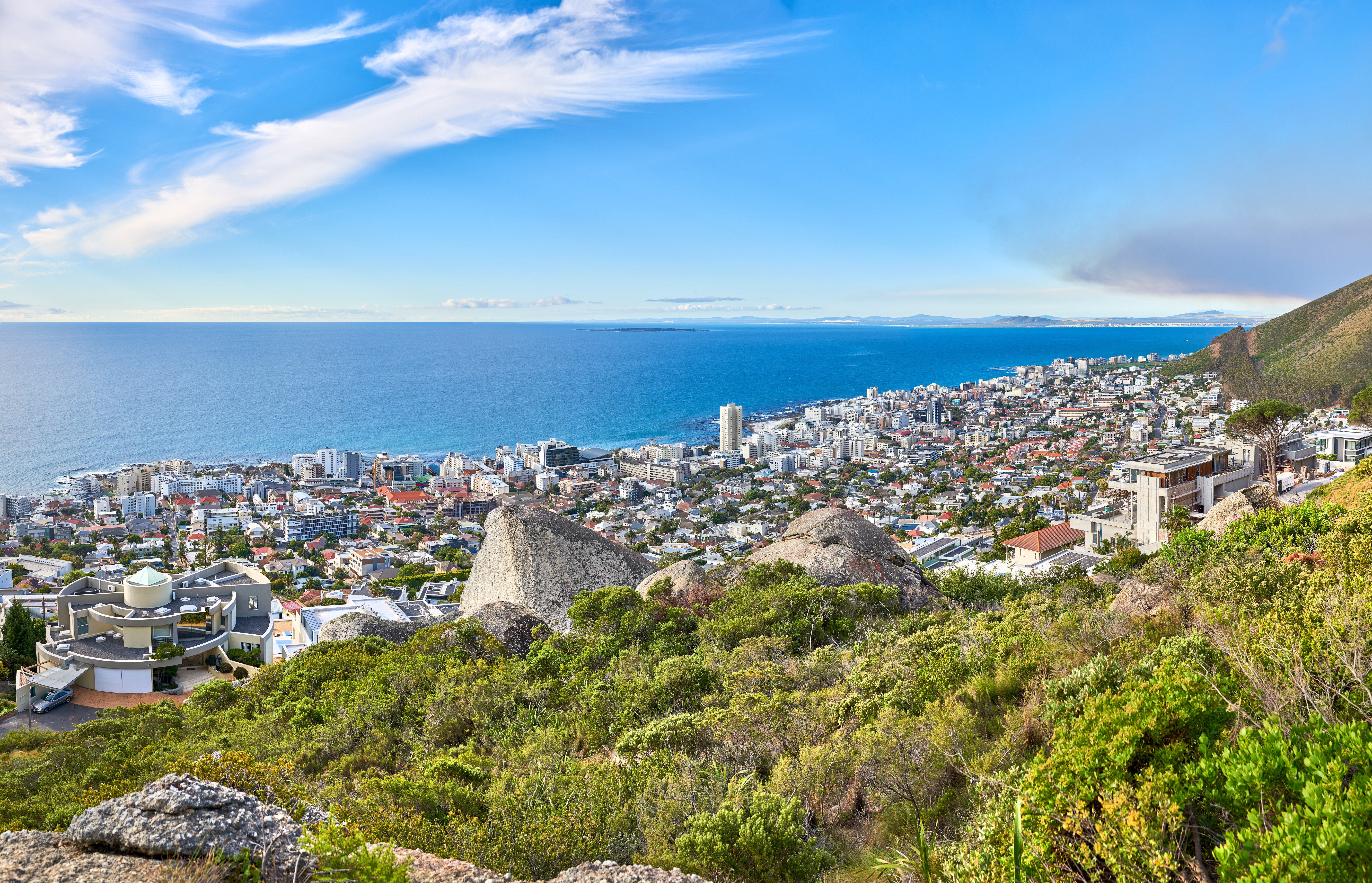 Panoramic view of Sea Point, Cape Town, showing the city meeting the Atlantic Ocean under a blue sky.