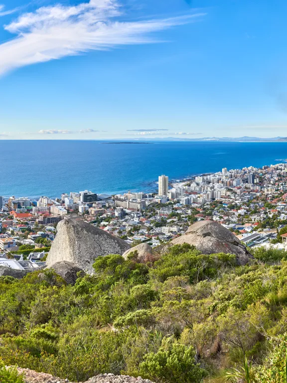 Panoramic view of Sea Point, Cape Town, showing the city meeting the Atlantic Ocean under a blue sky.