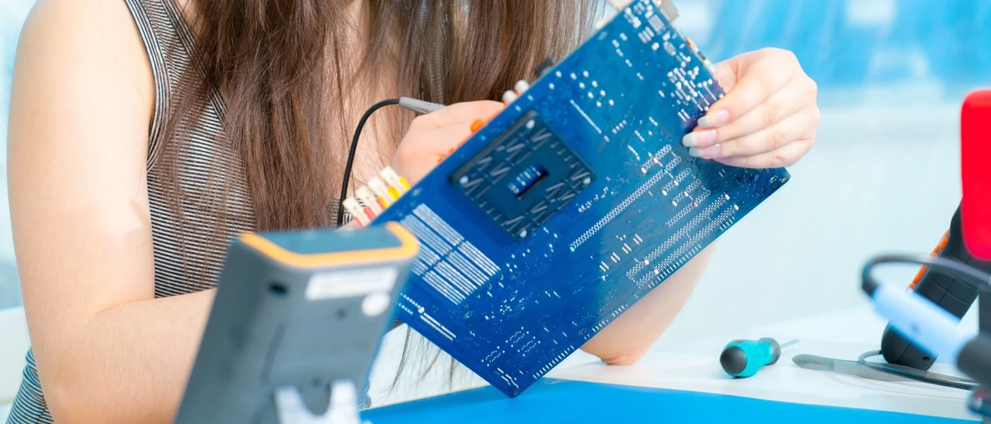 Female student working on a computer motherboard for her computer studies course. 