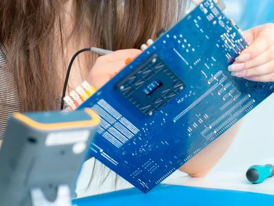 Female student working on a computer motherboard for her computer studies course.