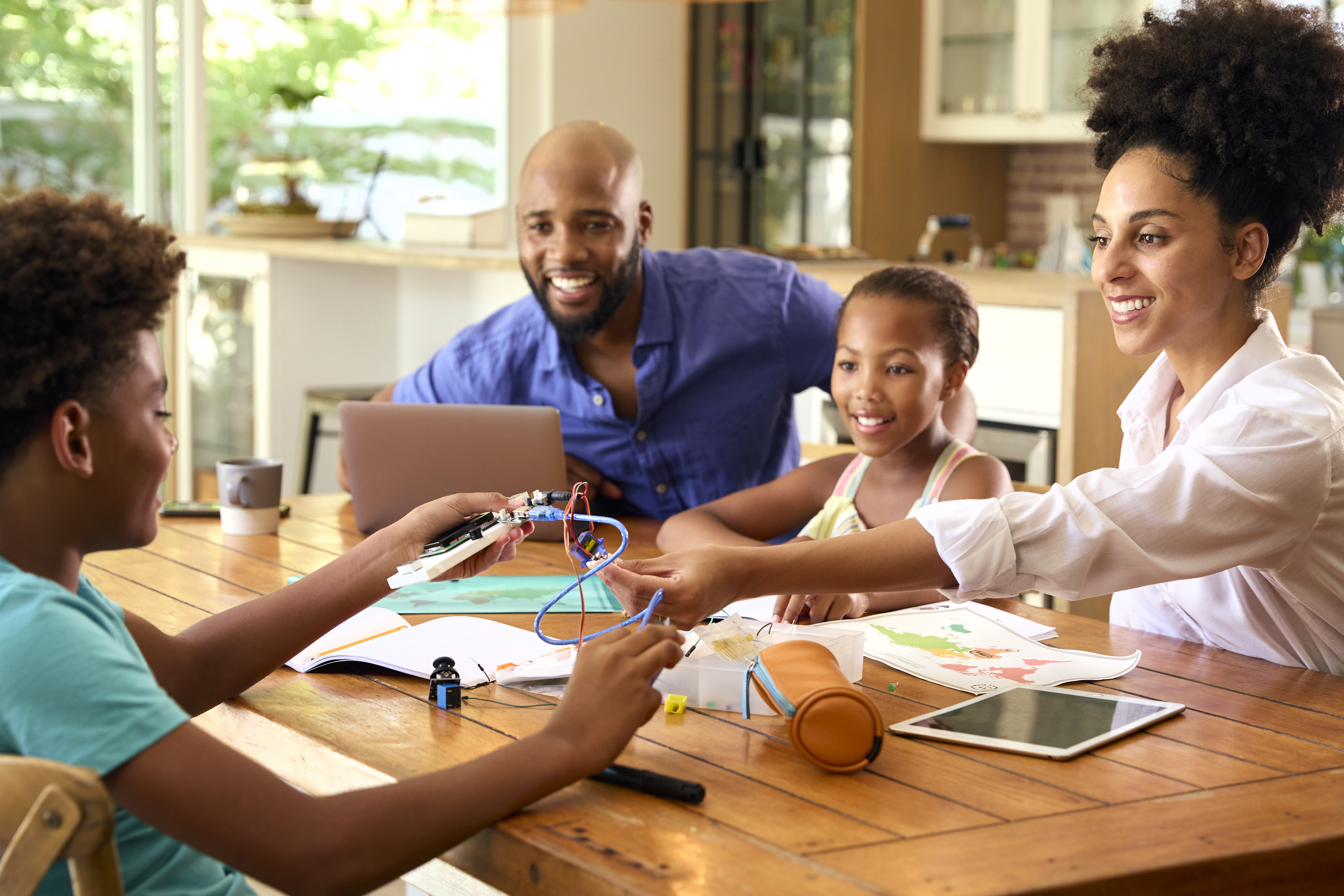 Parents and children collaborating on a creative project at home with learning materials