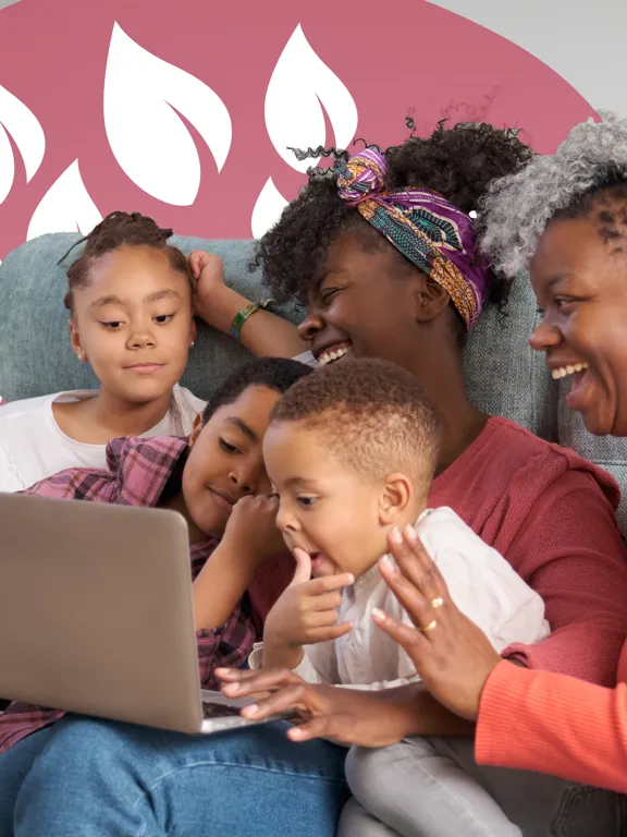 Family of five sharing a moment of learning and laughter together on the sofa with a laptop.