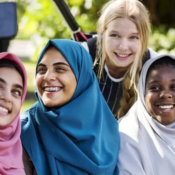 Teenagers using a phone to take a group photo.