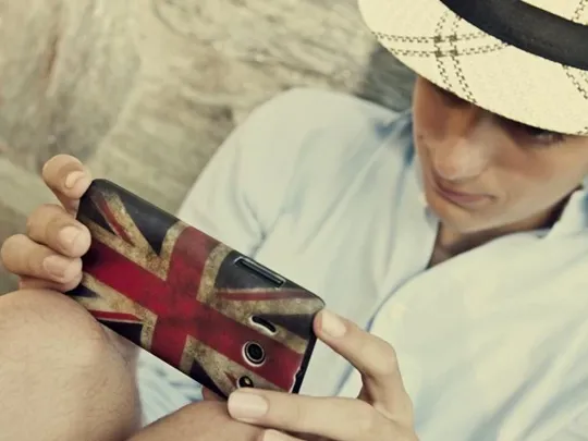 Someone using their phone with a Union Jack phone case.