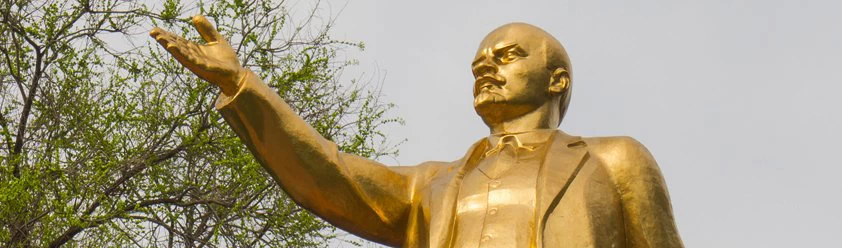 A golden statue of a man with his hand outstretched. 