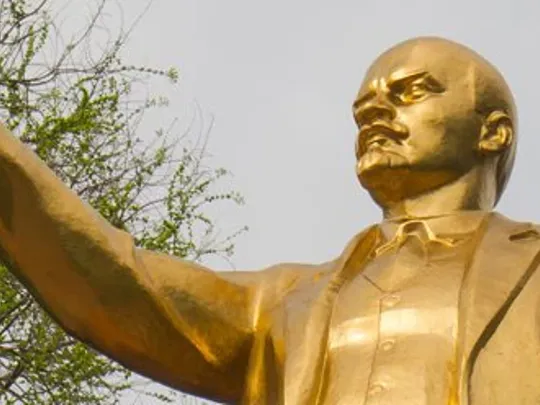 A golden statue of a man with his hand outstretched.