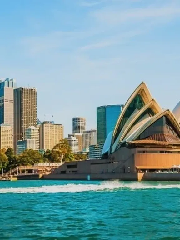 A landscape view of the Sydney Opera House, and the surrounding skyline.
