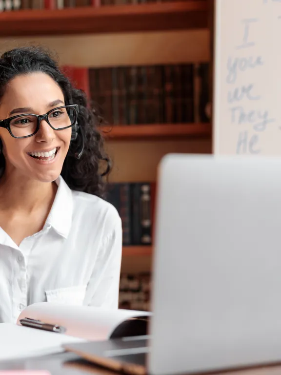 A friendly and approachable online tutor with a headset on, ready to help students succeed.