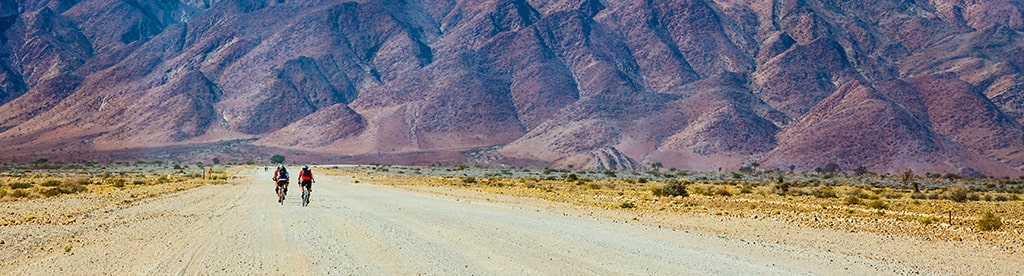 A cyclist on a long straight road. 