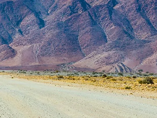 A cyclist on a long straight road.