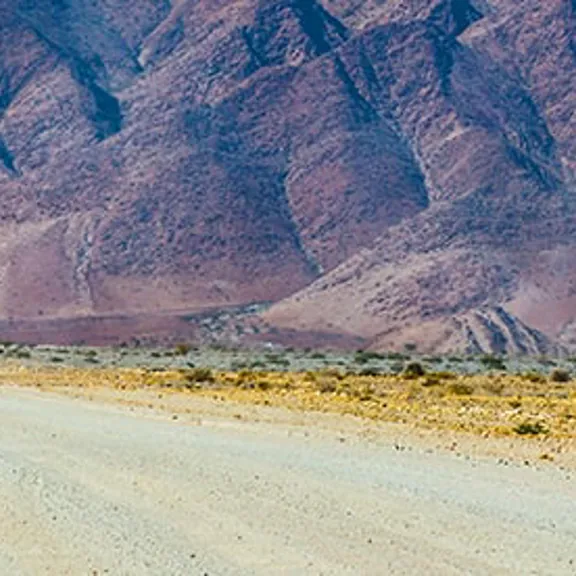A cyclist on a long straight road.