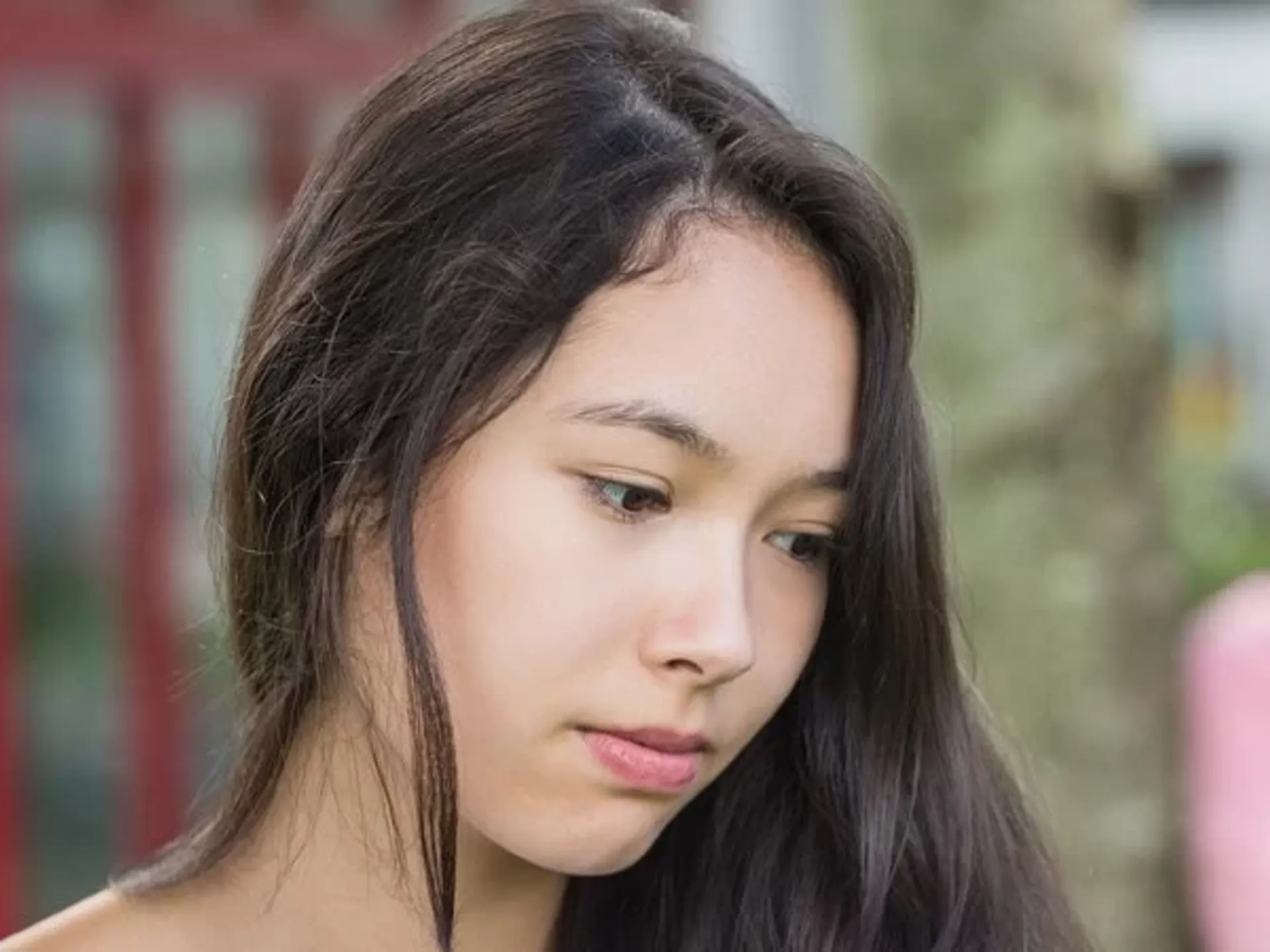 Teenage girl being excluded from the group and being laughed at by her peers.