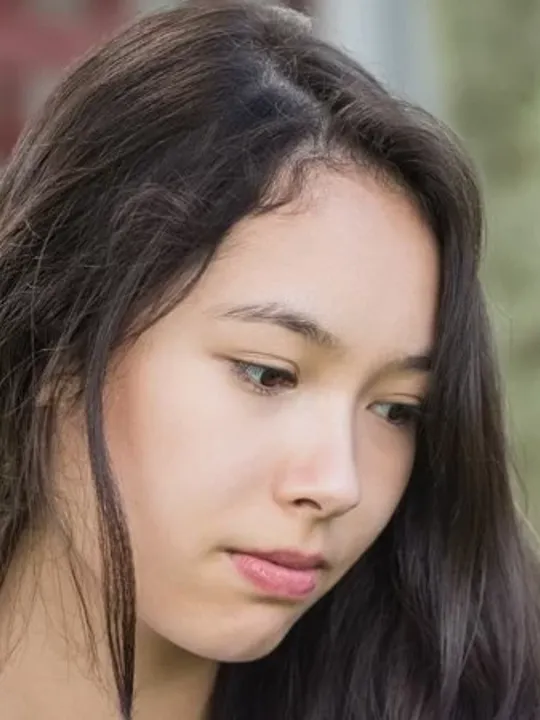 Teenage girl being excluded from the group and being laughed at by her peers.