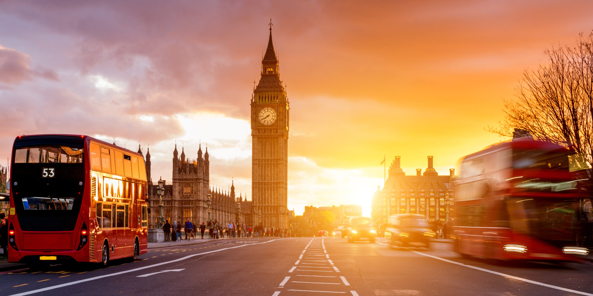 An elapsed photo of a bridge over the River Thames, with Big Ben in the background at sunset.