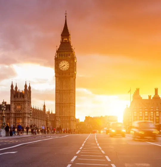 An elapsed photo of a bridge over the River Thames, with Big Ben in the background at sunset.