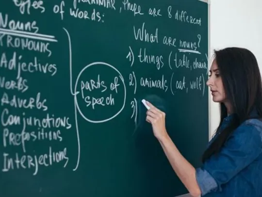 An English teacher writing on a blackboard.