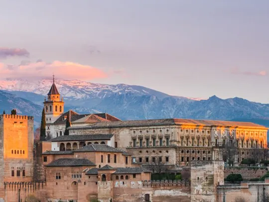 A landscape view of a Spanish castle at sunset.