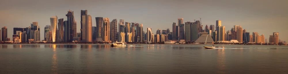A landscape view of a Qatari city skyline, at sunset. 